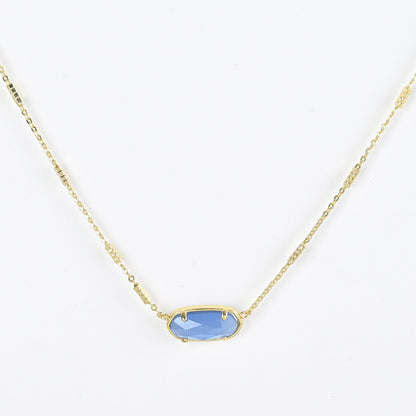 Oval crystal pendant necklace with light blue stone and gold bezel on a gold chain