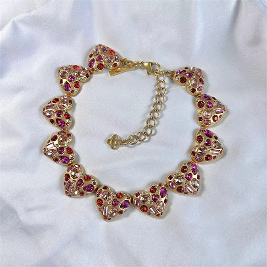 Vintage heart-shaped crystal necklace with gold chain and pink/purple rhinestone hearts