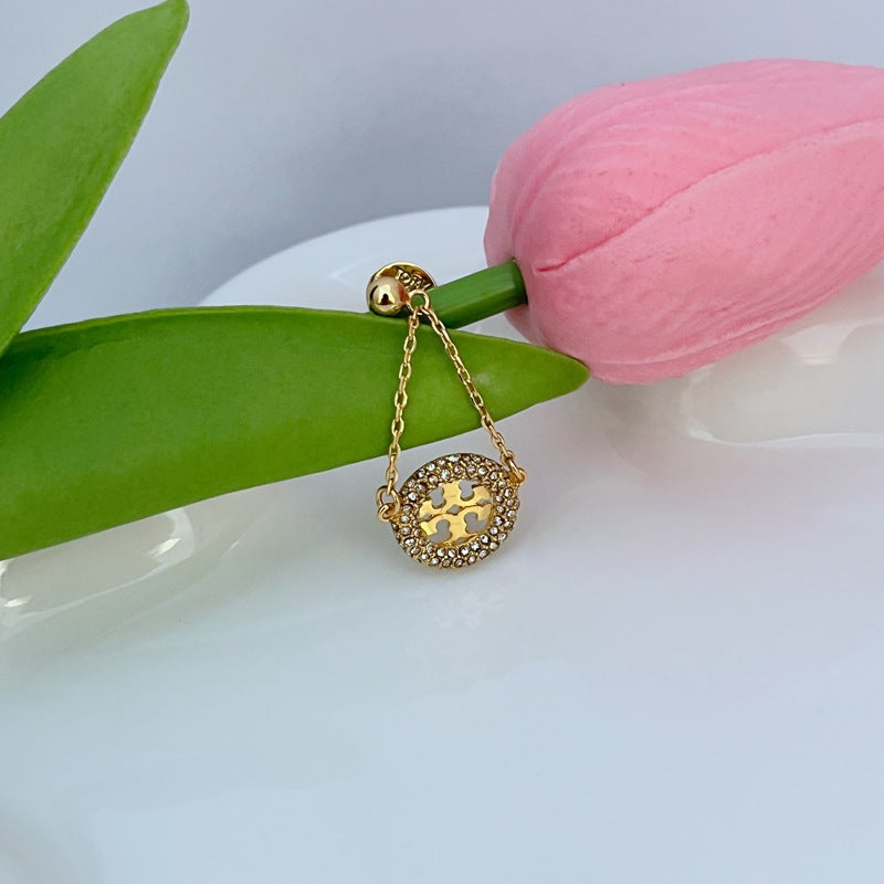 Gold hoop drop earrings featuring round pavé rhinestone charm with cutout center