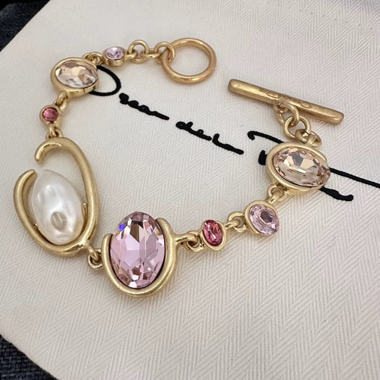 Gold-tone crystal and pearl O-ring bracelet with pink and purple oval drops