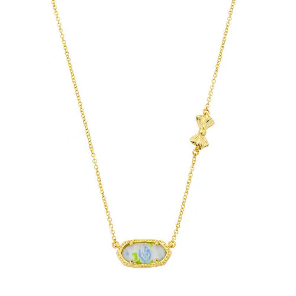 Gold butterfly pendant necklace with oval blue-and-white enamel charm