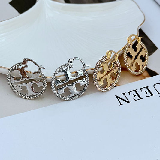 Tory Burch rhinestone openwork metal hoop earrings, silver-tone with four-petal cutouts