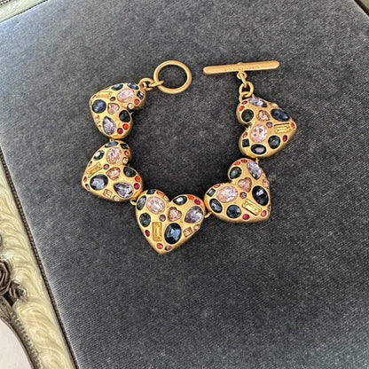 Heart charm bracelet with gold-tone links and multicolor gemstone accents