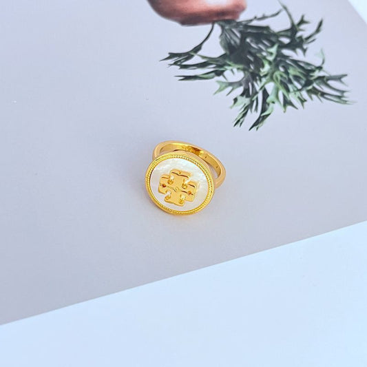 Gold round enamel logo ring with geometric emblem, white center, adjustable band