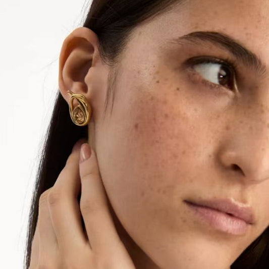 Teardrop loop earrings with champagne-toned center stones, worn at the ear