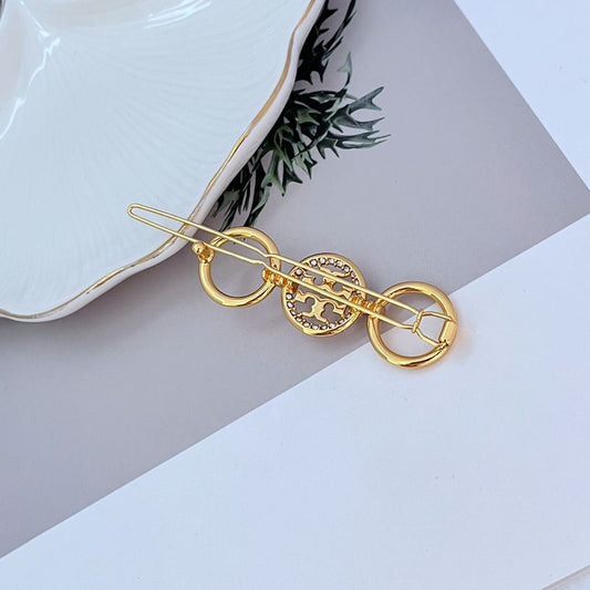 Goldfarbener runder Haarclip mit Diamantbesatz, verschlungene Oval-Ösen