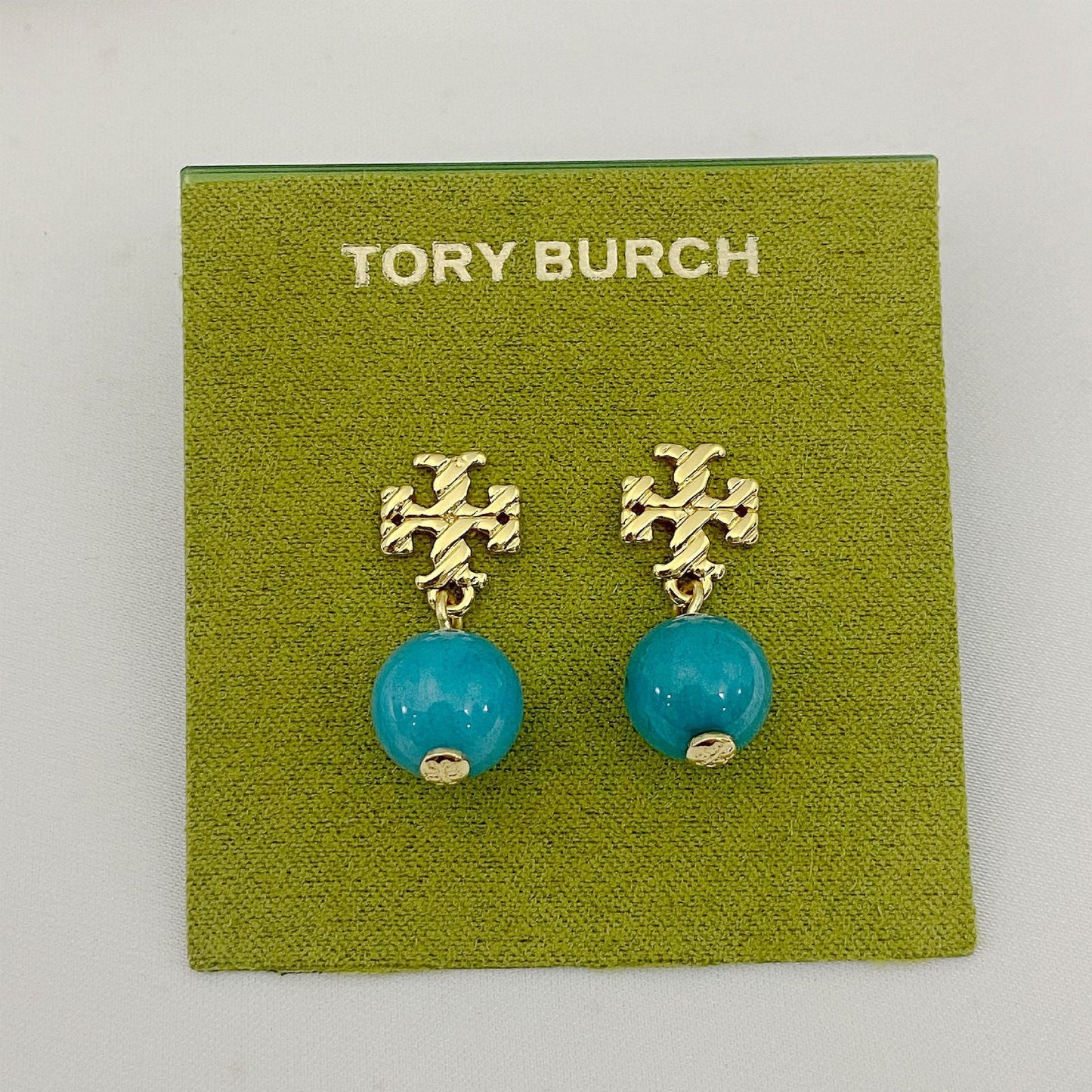 Gold-tone agate pendant earrings with round teal stones and leaf-like top motif