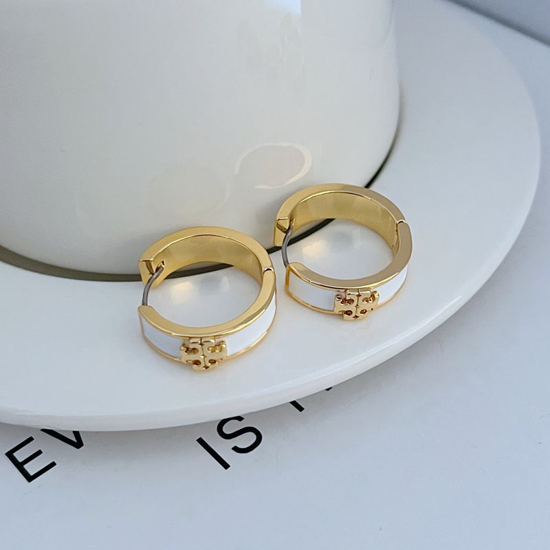 Gold-tone round hoop earrings with white enamel band and decorative front charm