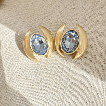 Gold-tone oval crystal stud earrings with light blue faceted stones