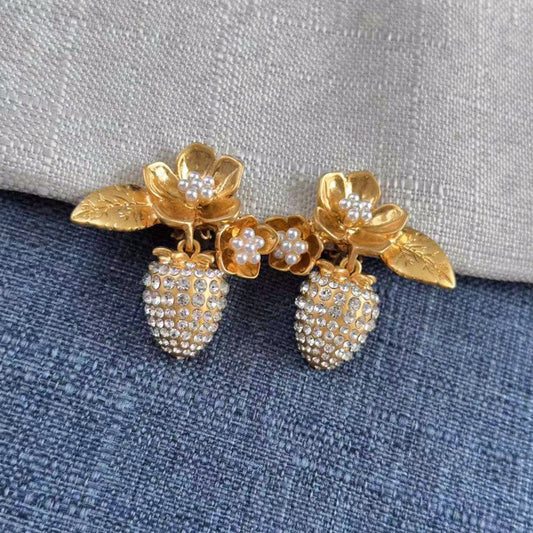 Gold-tone clip-on earrings with faux pearl flower details and rhinestone strawberry charms