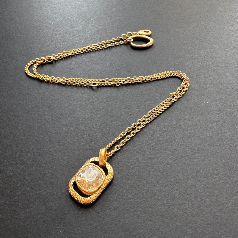Hammered square pendant necklace with clear faceted gemstone and gold chain with clasp