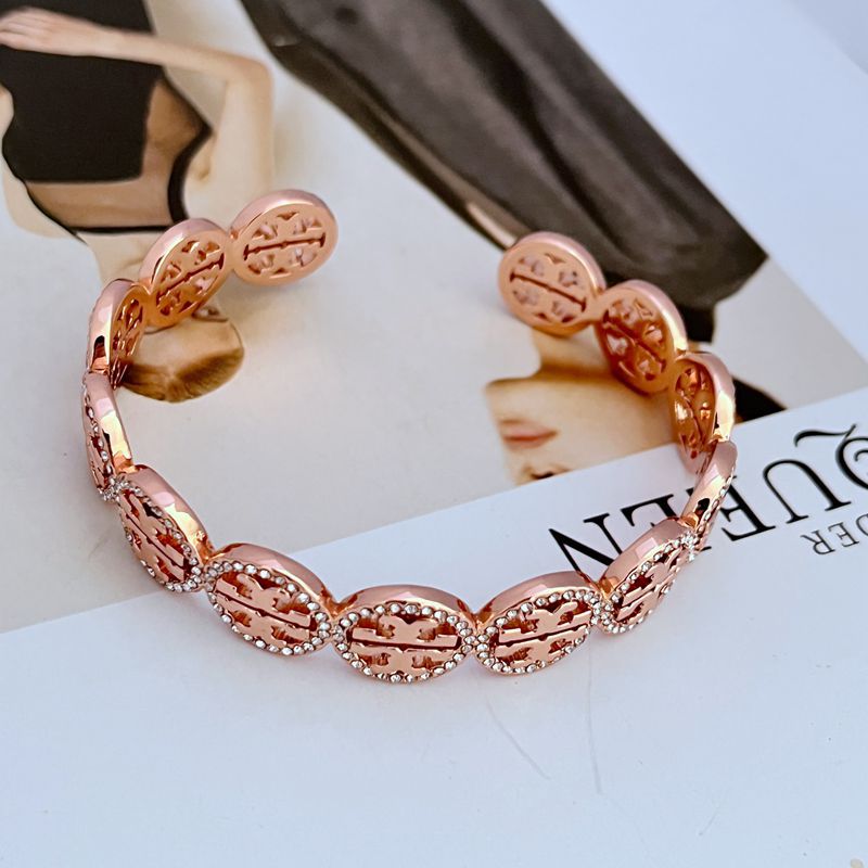 Rose-gold openwork logo bangle with diamond-studded circular links