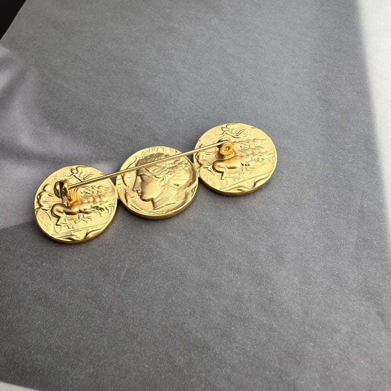 Gold-tone coin brooch with three overlapping round profile coin faces
