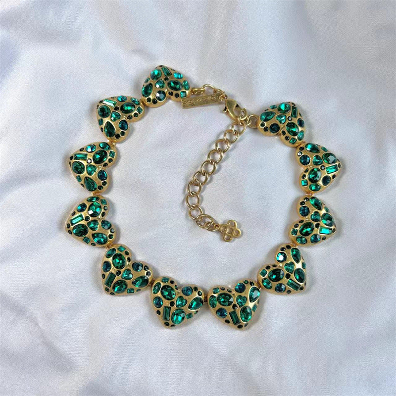 Vintage heart-shaped crystal necklace with gold chain and teal/green rhinestone hearts