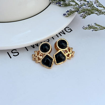 Gold-tone multi-stone stud earrings with black acrylic discs and square stones