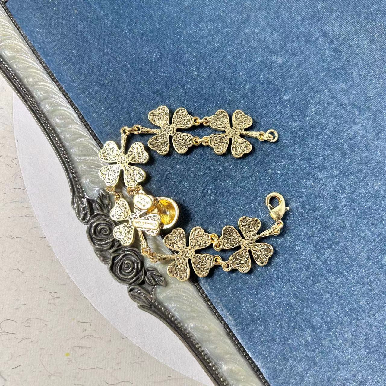 Four-leaf clover charm bracelet with gold-tone chain, glitter clovers, and clasp