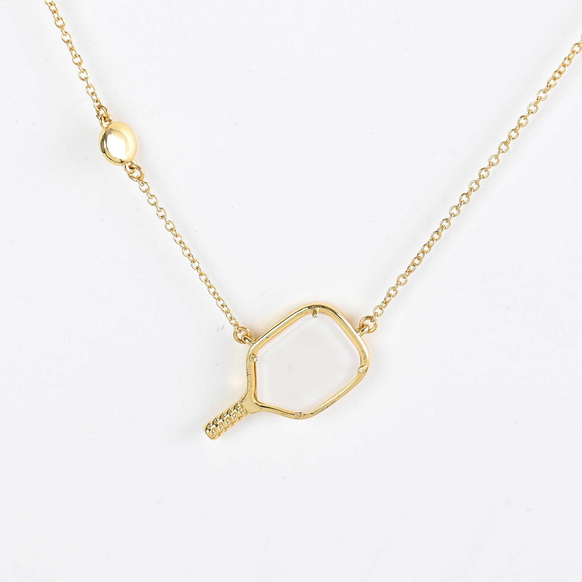 Gold tennis racket pendant necklace with heart outline pendant and small handle