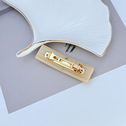 Milky white acrylic hair clip with gold-tone clasp and logo front