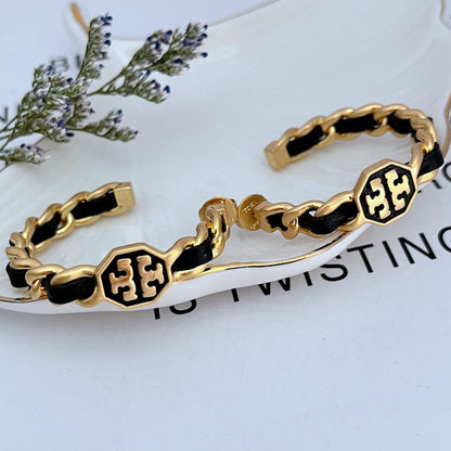 Leather-woven logo hoop earrings with black leather links and gold-tone logo medallions