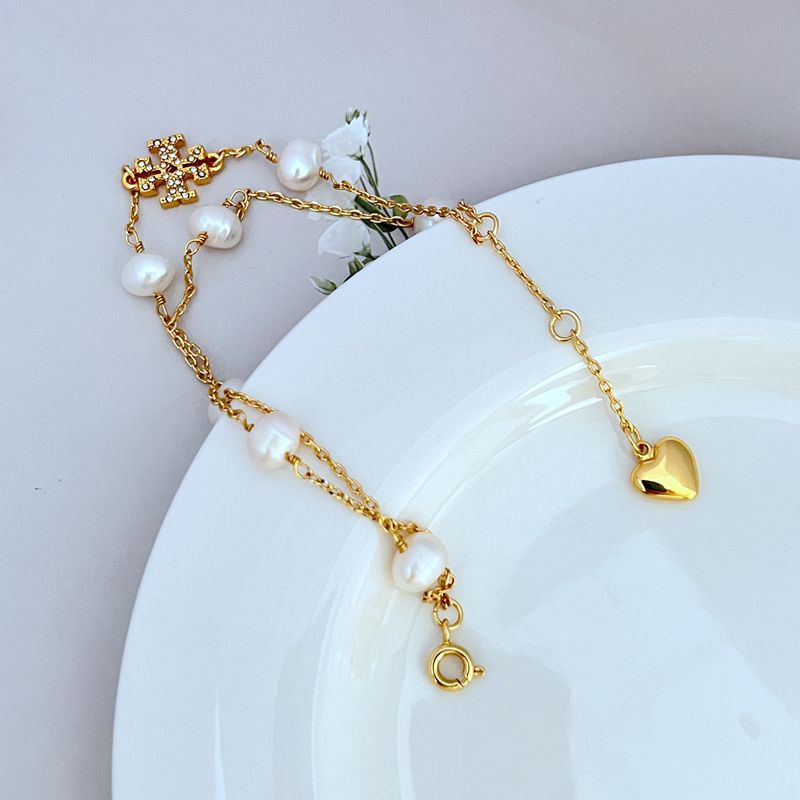 Goldfarbenes Perlenarmband mit Herz-Anhänger, weißen Perlen und Schiebeverschluss