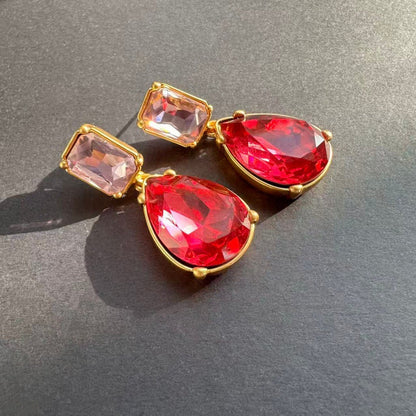 Teardrop-cut diamond stud earrings with red teardrop stones and pink-red square studs, gold-tone