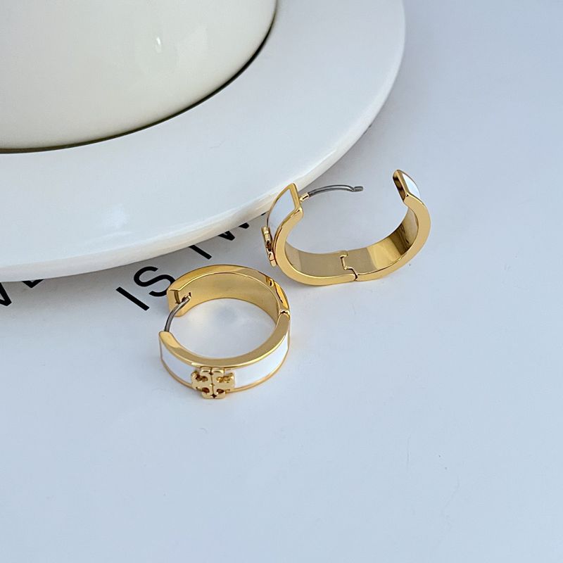 Gold-tone round hoop earrings with enamel band and decorative front charm, pair view