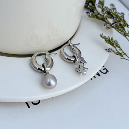 Silver asymmetrical pearl hoop earrings with dangling white pearl and charm detail