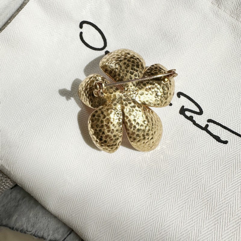 Gold-tone cherry blossom brooch clasp and pin hinge on the back, with textured petals