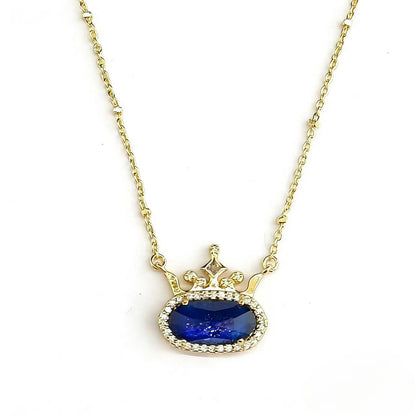 Gold-plated princess crown necklace with blue oval gemstone and diamond-style halo