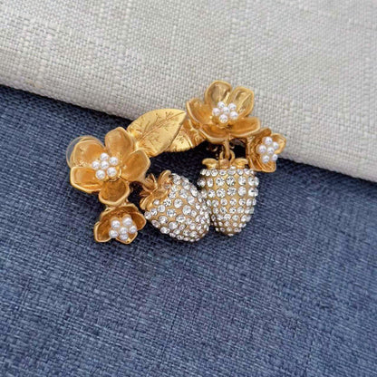 Gold-tone clip-on earrings with layered pearl flower accents and rhinestone strawberry drops