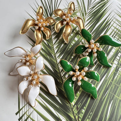 Floral enamel earrings with gold petals, white pearls, and green enamel flower leaves