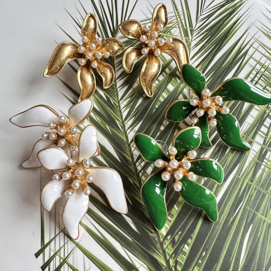 Floral enamel earrings with gold petals, white pearls, and green enamel flower leaves