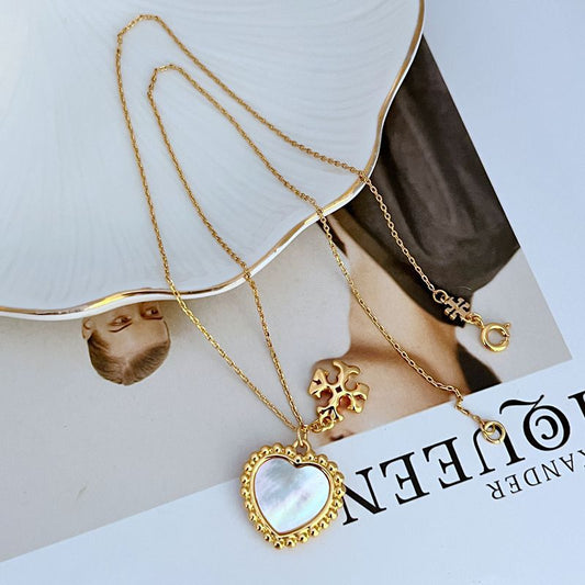 Gold-tone heart pendant necklace with small flower charm and round link chain