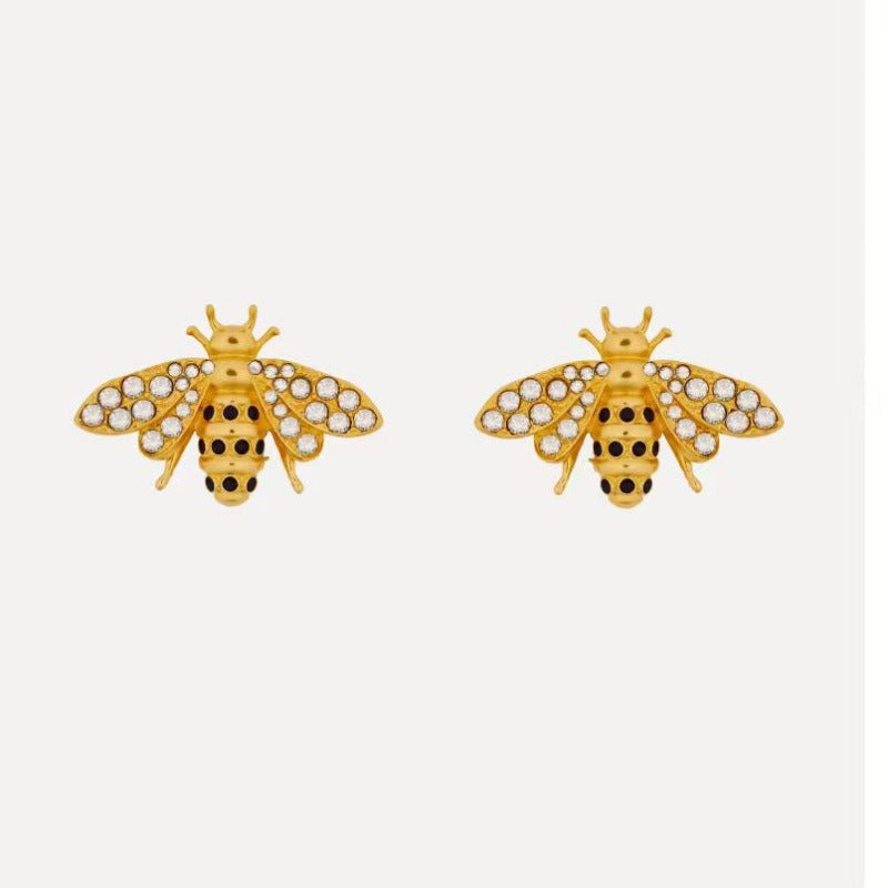 Bee insect earrings with gold-tone body and clear crystal wings, stud style