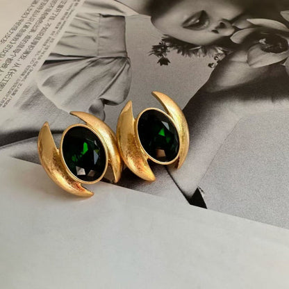 Oval crystal stud earrings with dark green gem and gold-tone crescent claws
