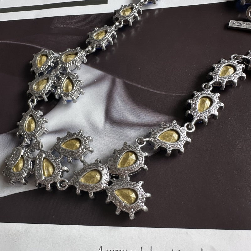 Silver-tone crystal necklace with yellow teardrop stones and linked chain