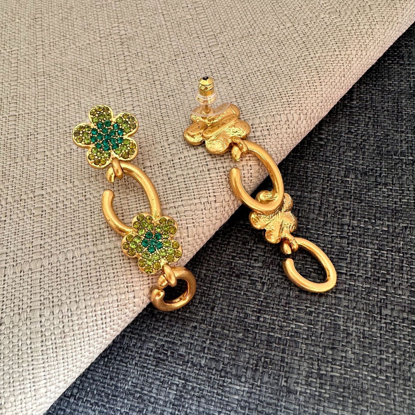 Floral dangle hoop earrings in gold tone with green crystal flower clusters and loops