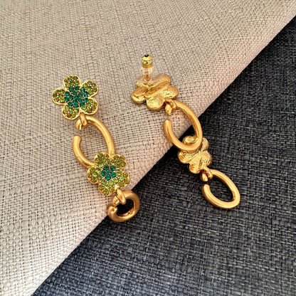 Floral dangle hoop earrings in gold tone with green crystal flower clusters and loops