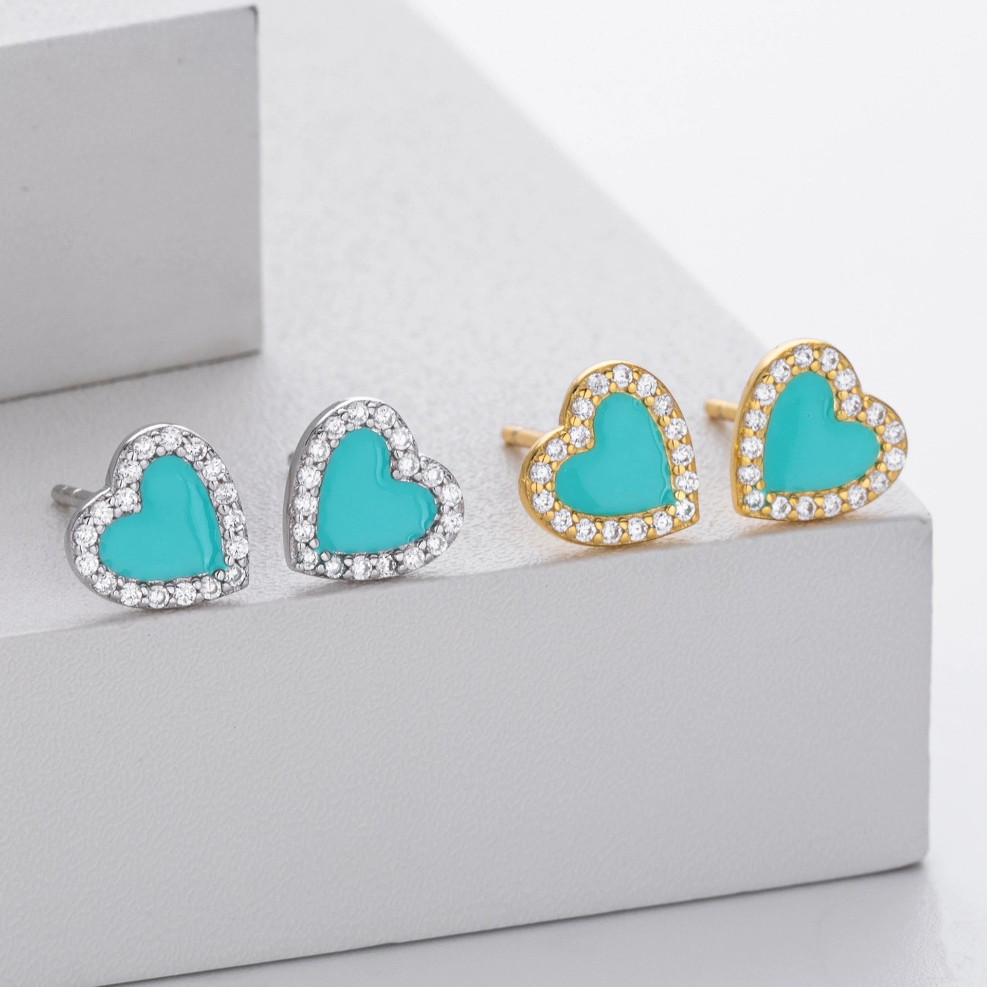 Heart stud earrings set showing silver and gold-tone styles with turquoise centers and clear stones.