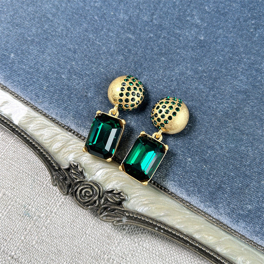 Gold-tone stud earrings with green square-cut drop stones and round jeweled caps