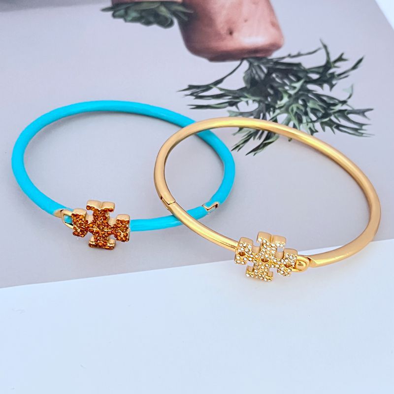 Gold & blue openable bangles with enameled diamond cross charm centerpiece