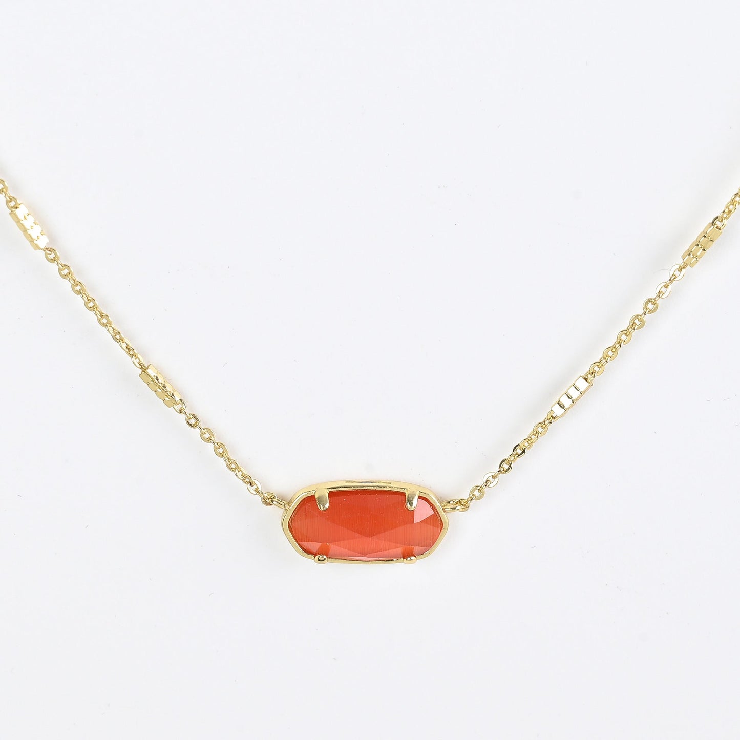 Oval crystal necklace with gold-tone chain and red oval stone