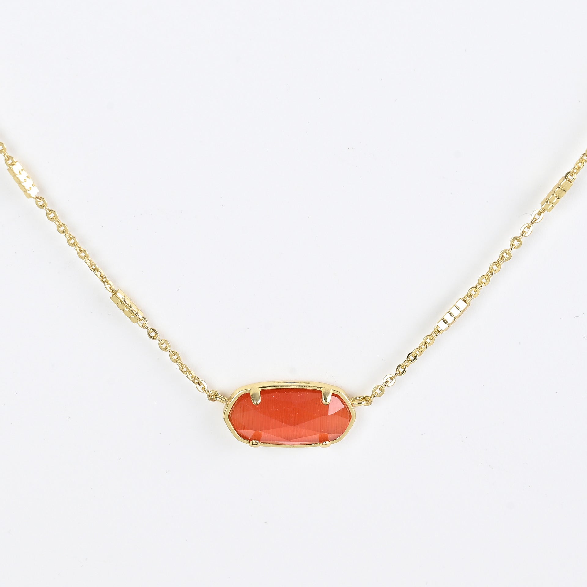 Oval crystal necklace with gold-tone chain and red oval stone