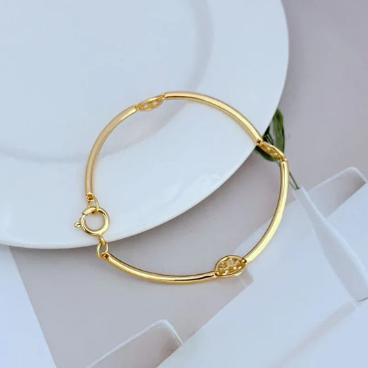 Gold-tone metal bangle with pavé round logo and hinged clasp detail