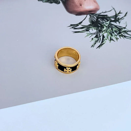 Gold-tone wide enamel band ring with black enamel inset and logo detail