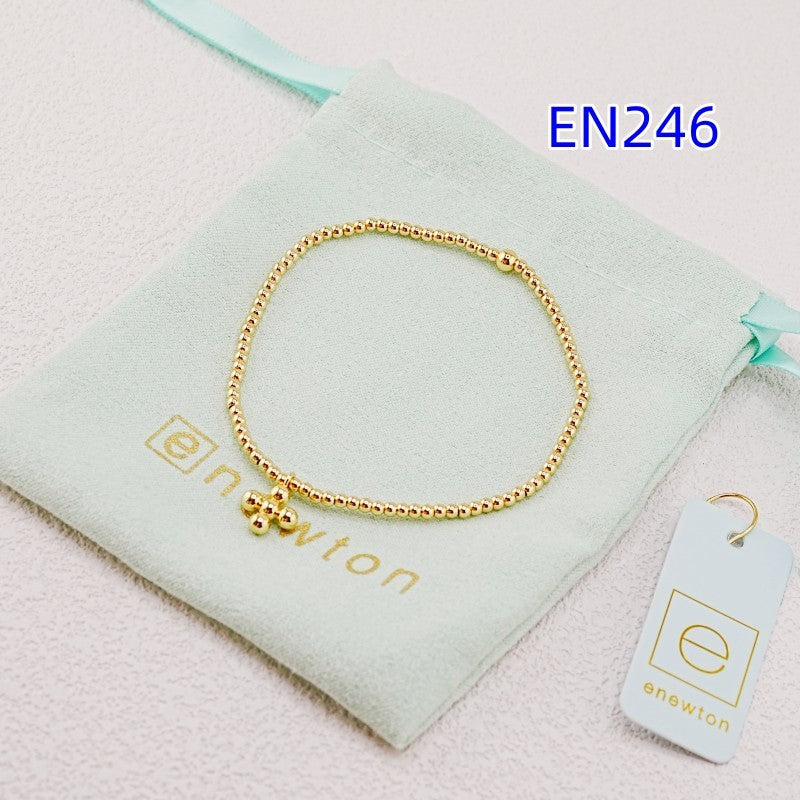 Elastic beaded cross pendant bracelet with gold-tone round beads and charms