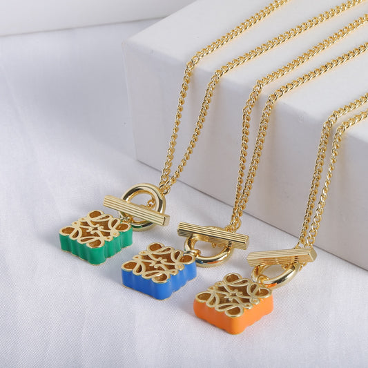 Enamel square cutout logo OT necklace charms display: green, blue, and orange enamel squares