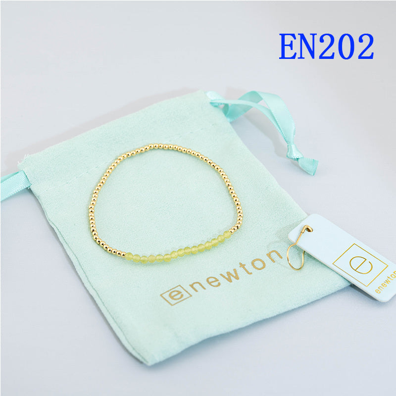 Elastic beaded bracelet with gold round beads in a single continuous strand.