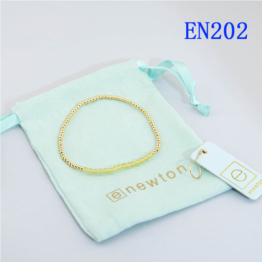 Elastic beaded bracelet with gold round beads and light yellow accents