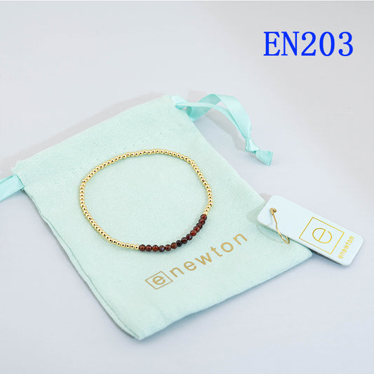 Elastic beaded bracelet with gold round beads and dark red beaded section